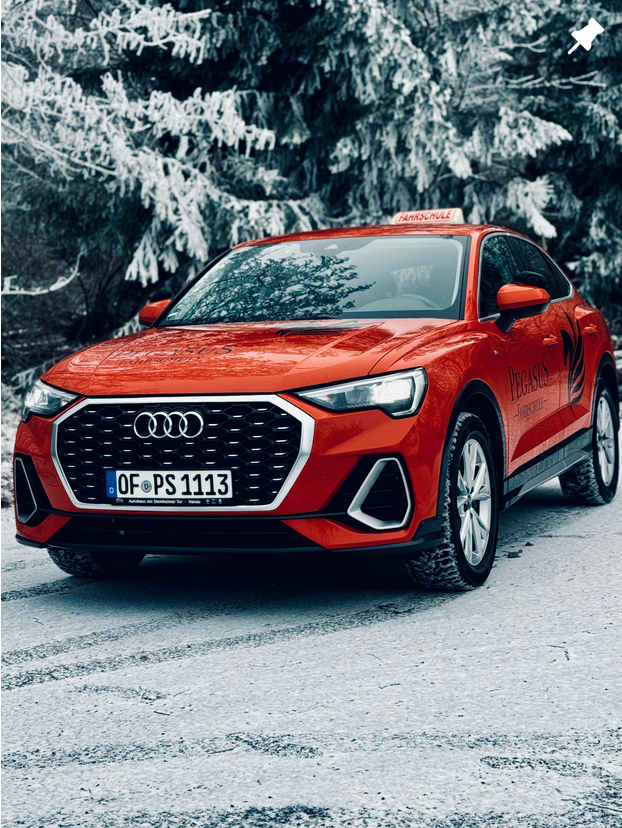 Rotes Fahrschulauto im Schnee